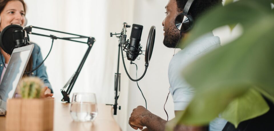 Happy multiracial coworkers recording podcast